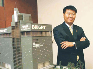 Hsu and the model of his company`s headquarters building.