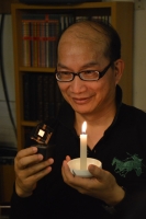 Jou compares his candlelight-like OLED (in right hand) with candle light. (Photo courtesy of Prof. Jou) 