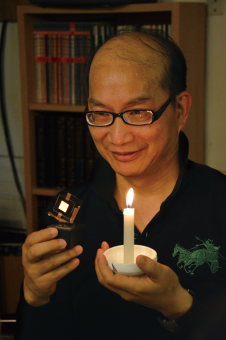 Jou compares his candlelight-like OLED (in right hand) with candle light. (Photo courtesy of Prof. Jou) 