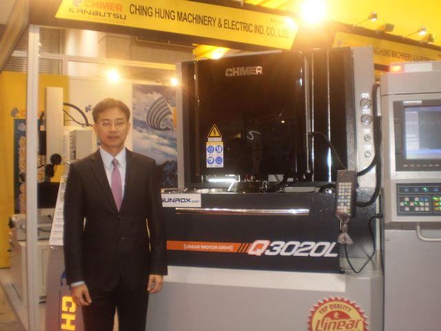 Brad Wang, Chmer's vice president, is proud of the technologies and key components built into his company's Q series high precision gantry-type liner motor drive EDM, seen behind him.