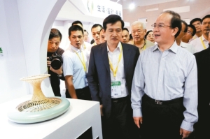 大陆文化部副部长丁伟（右一）昨天在文博会上参观台湾工艺品。 特派记者郭玫君／摄影