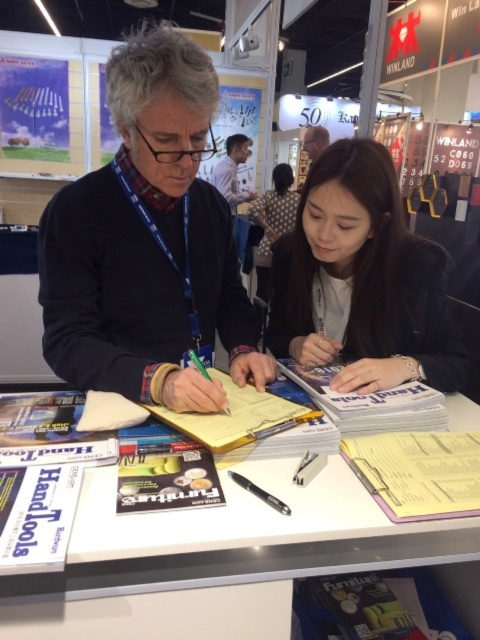 Economic Daily News (CENS) publication team at the 2018 IHF helps a buyer fill out a business matchmaking form. (Photo courtesy of CENS)